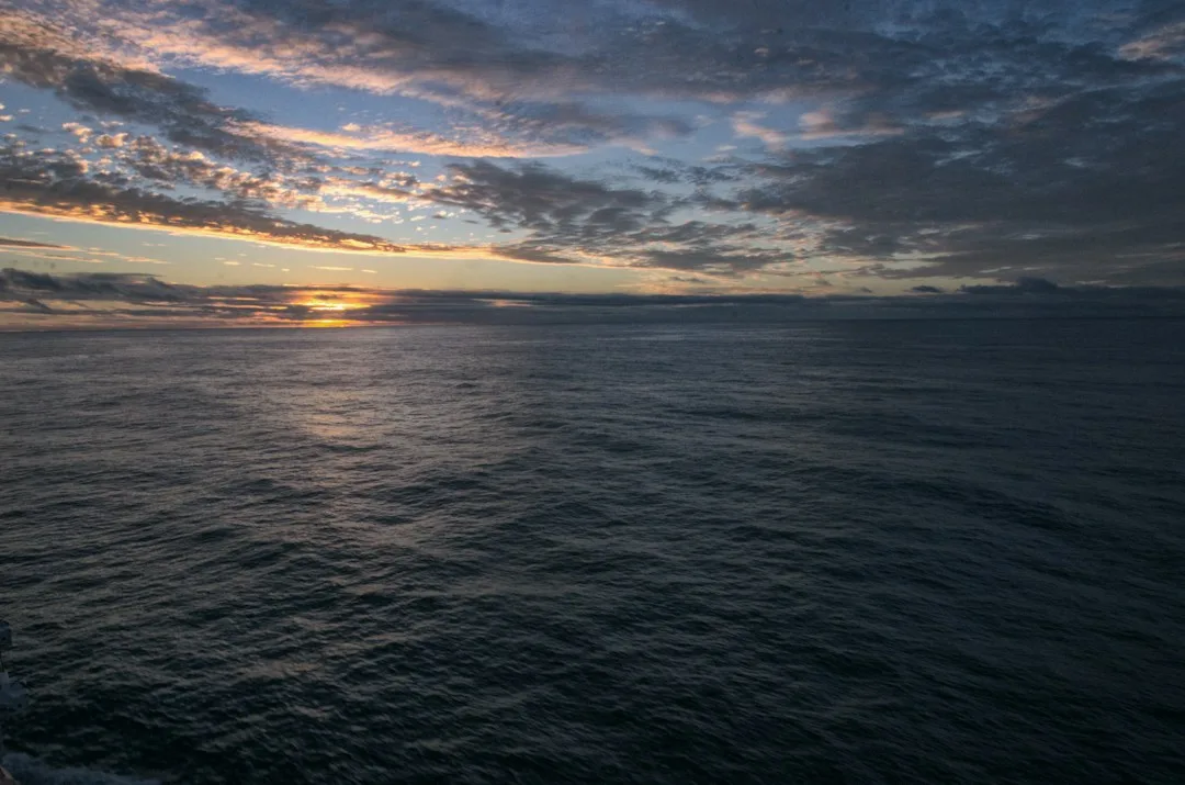 An open ocean horizon at sunset, suggesting space for reflection and discovery.